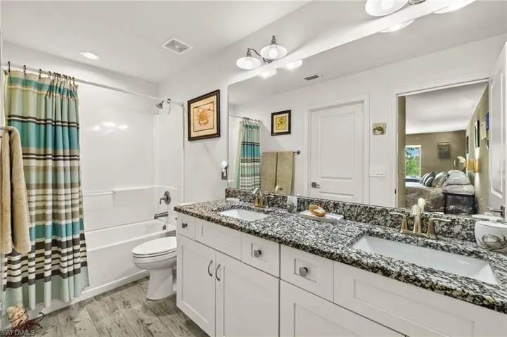 Primary bathroom has dual sinks and granite counter tops.  Large walk-in closet comes off of this bathroom with the door to the left side just out of view in this photo.