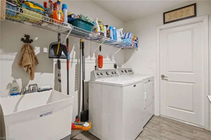 Large laundry room with plenty of storage and a laundry sink.
