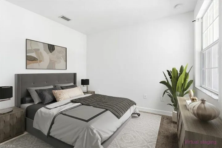 #2 Spacious bedroom with light-colored walls and a window offering natural illumination