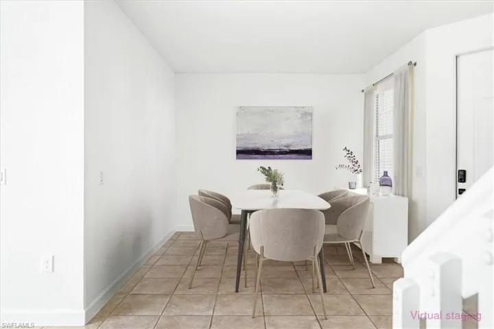 Dining area featuring neutral wall tones, tile flooring, a window with blinds, and white trim throughout