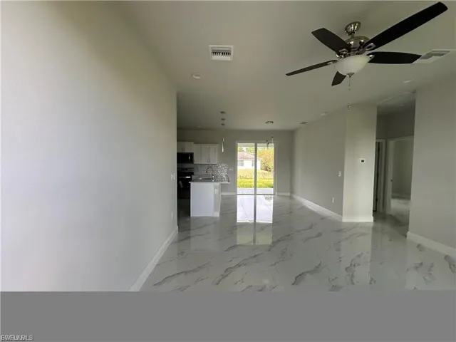 Spare room featuring light marble finish flooring and ceiling fan