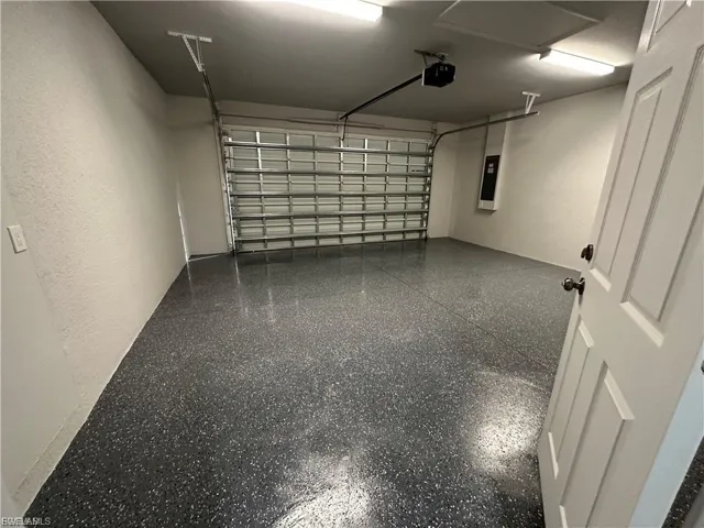 Garage featuring electric panel and a garage door opener