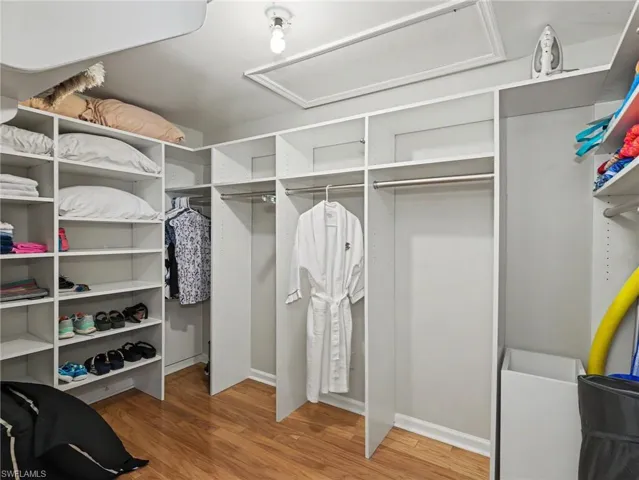 Custom closet organization system featuring white shelving and hanging rods