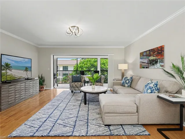Expansive living area featuring wood-finish flooring and crown molding