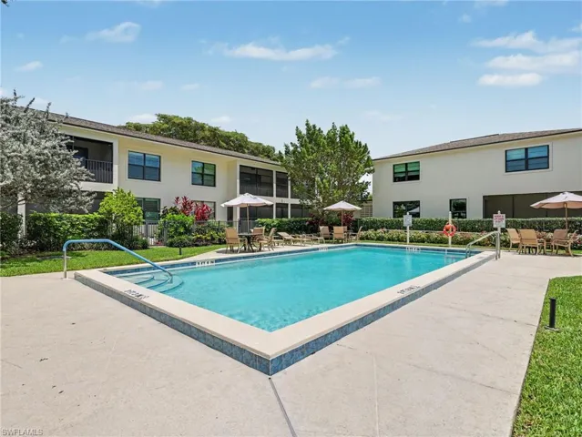Rectangular swimming pool with integrated steps, surrounded by a concrete deck and a low tiled border