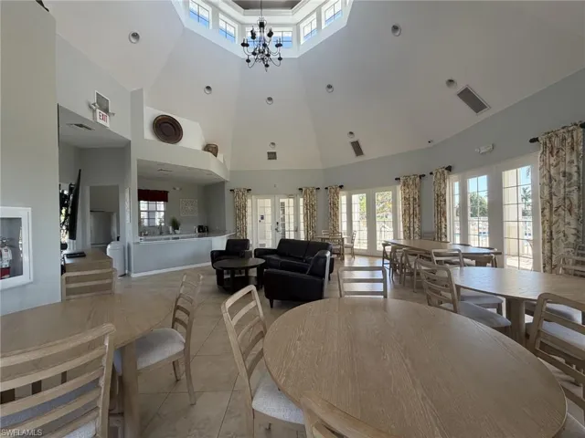Dining space featuring healthy amount of natural light, light tile patterned flooring, and a chandelier