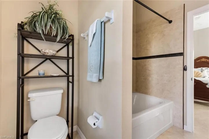 Ensuite bathroom featuring soaker tub / shower combination and toilet