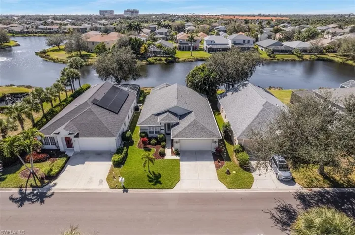 Aerial perspective of suburban area featuring a nearby body of water