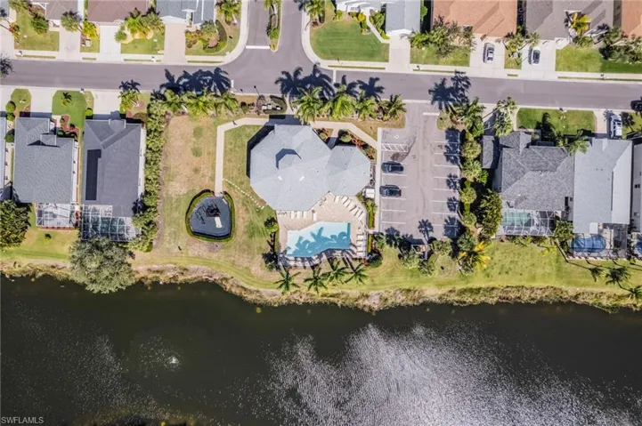 Aerial view of property and surrounding area featuring nearby suburban area and a nearby body of water