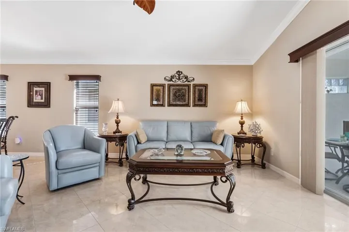 Living area with crown molding and tile patterned floors