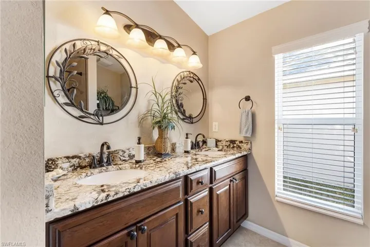Full bathroom with double vanity and baseboards
