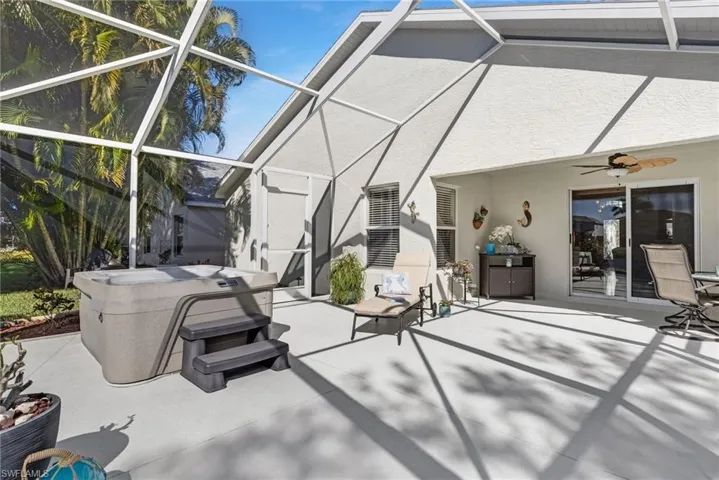 View of lanai, ceiling fan, and a hot tub