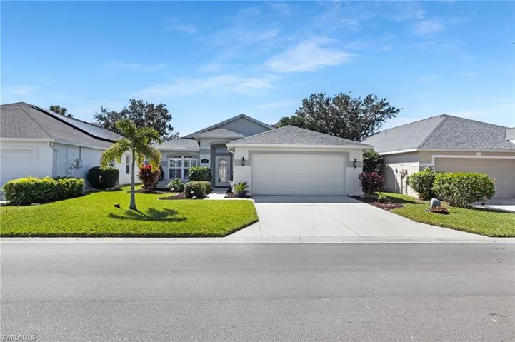 Ranch-style house featuring a garage, a front lawn, concrete driveway, and stucco siding