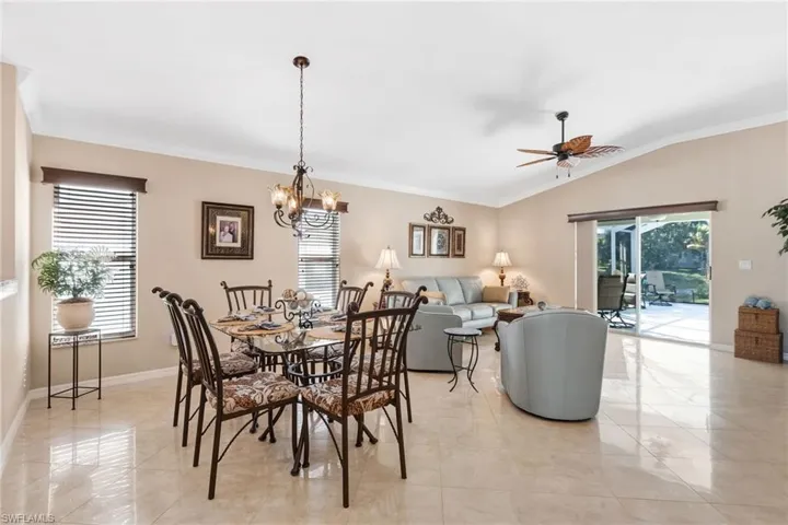 Dining room with crown molding, suspended lighting, lofted ceiling, and ceiling fan