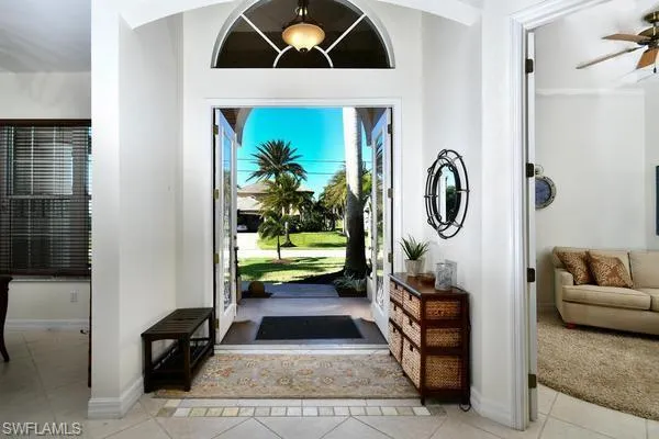 Foyer with light tile patterned floors and ceiling fan
