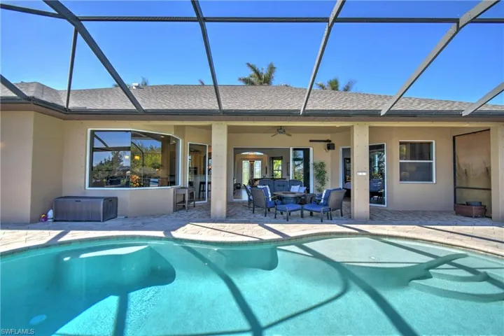 View of swimming pool with a lanai, ceiling fan, and a patio