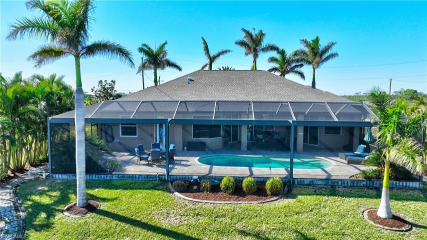 View of swimming pool with glass enclosure, a yard, and a patio