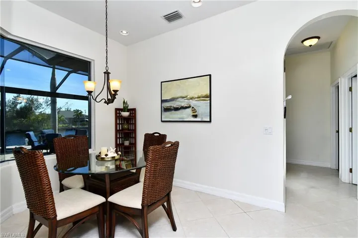 Dining area featuring a water view, light tile patterned floors, and an inviting chandelier