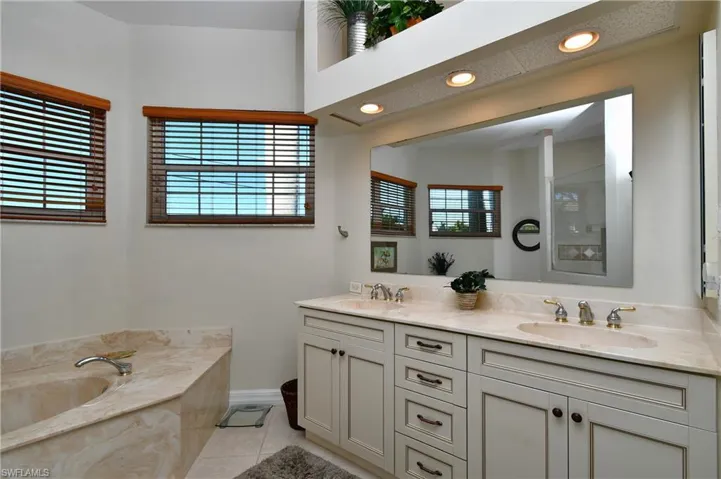 Bathroom featuring a bath, vanity, tile patterned floors, and a wealth of natural light