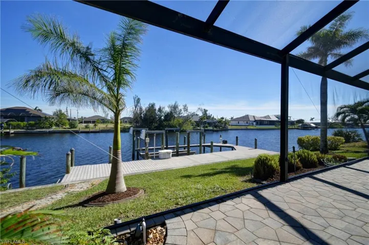 View of dock featuring a lawn and a water view