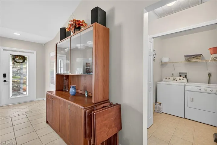 Laundry area with light tile patterned floors and independent washer and dryer