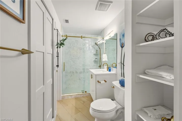 Full bathroom with vanity and a shower stall opened to the guest room