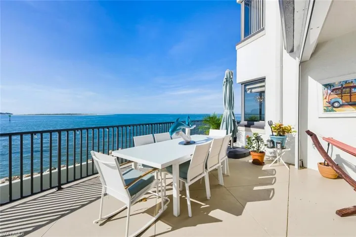 Balcony featuring outdoor dining space and a water view