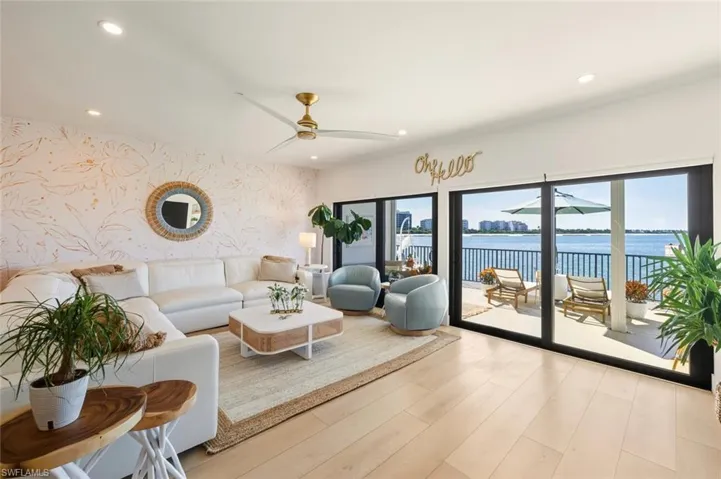 Living area with wallpapered walls, recessed lighting, light wood-style floors, a water view, and ceiling fan