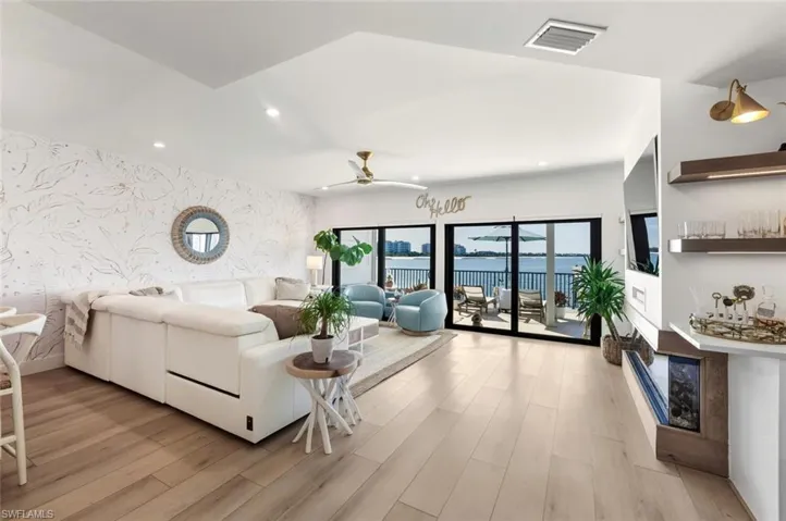 Living area featuring wallpapered walls, an accent wall, recessed lighting, light wood finished floors, and a ceiling fan