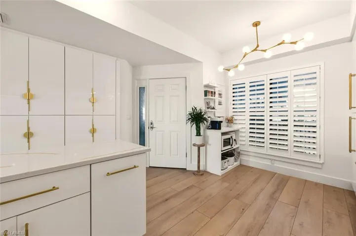 Entrance foyer with light wood finished floors and a chandelier