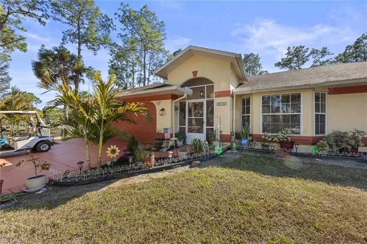 View of front of house with a front lawn, stucco siding, and roof with shingles