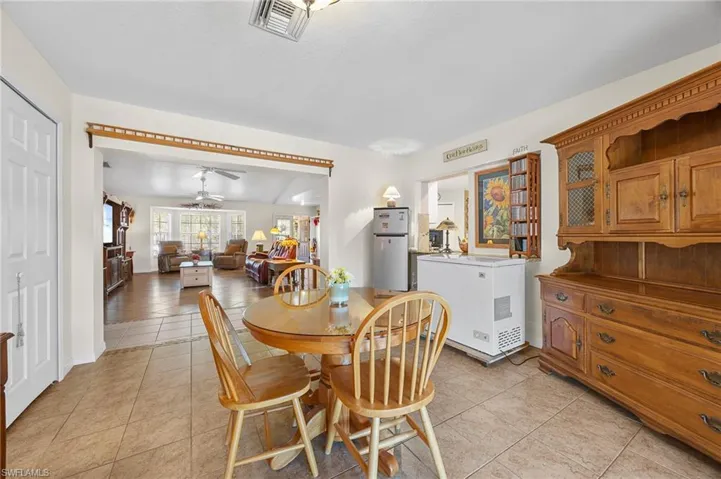 Dining area featuring light tile patterned flooring, ceiling fan, and lofted ceiling