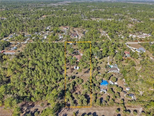 View of property location with a heavily wooded area and property boundaries highlighted