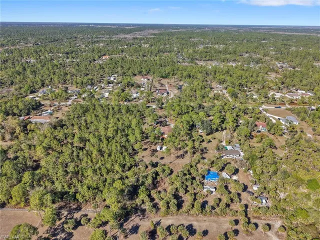 Aerial view of property's location featuring a heavily wooded area