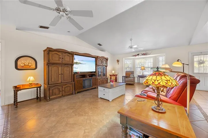 Living area with a ceiling fan, light tile patterned flooring, healthy amount of natural light, and inlaid floor details