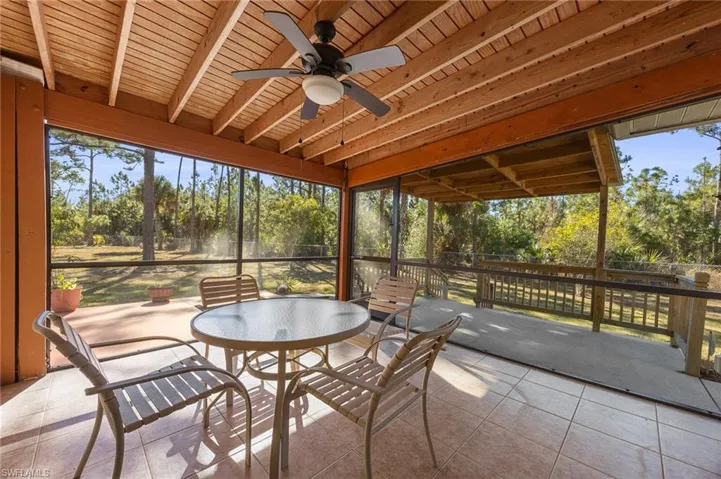 Sunroom with a ceiling fan, outdoor dining space, beam ceiling, and healthy amount of natural light