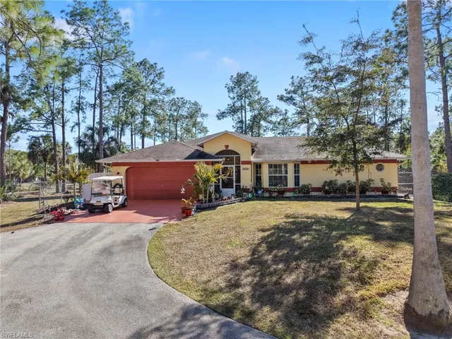 Single story home with asphalt driveway, a shingled roof, an attached garage, and stucco siding