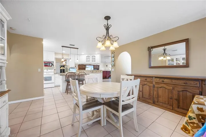Dining room featuring suspended lighting, arched walkways, and light tile patterned floors