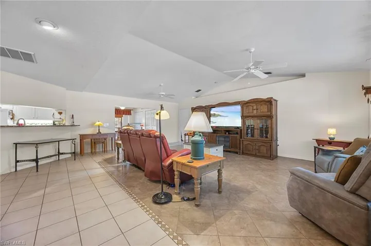 Living room with light tile patterned flooring and a ceiling fan