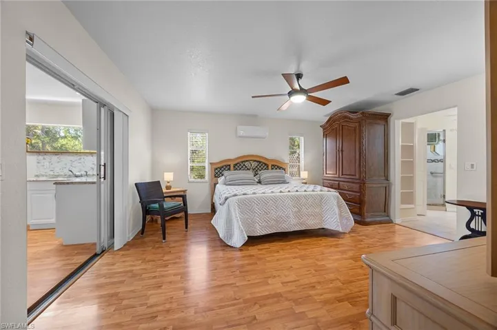 Bedroom featuring light wood-type flooring, ceiling fan, and a wall mounted mini split
