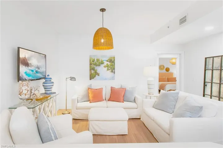 Living area with light wood-style flooring and visible vents