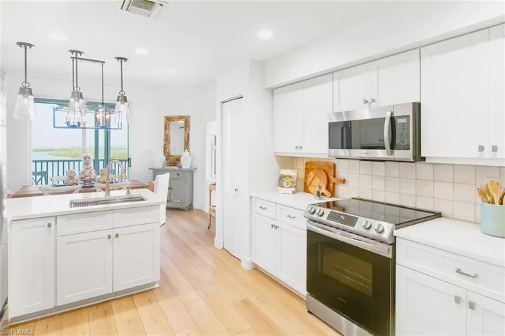 Kitchen with an inviting chandelier, visible vents, a sink, stainless steel appliances, and tasteful backsplash