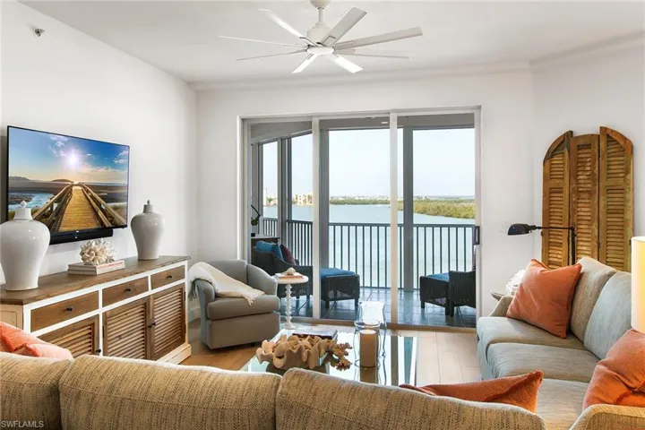 Living area with a water view, ceiling fan, and wood finished floors
