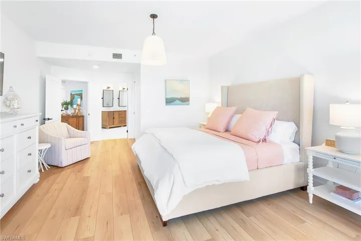 Bedroom featuring connected bathroom, light wood-type flooring, and visible vents