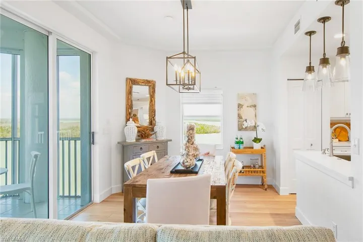 Dining space featuring baseboards, light wood finished floors, a chandelier, and visible vents