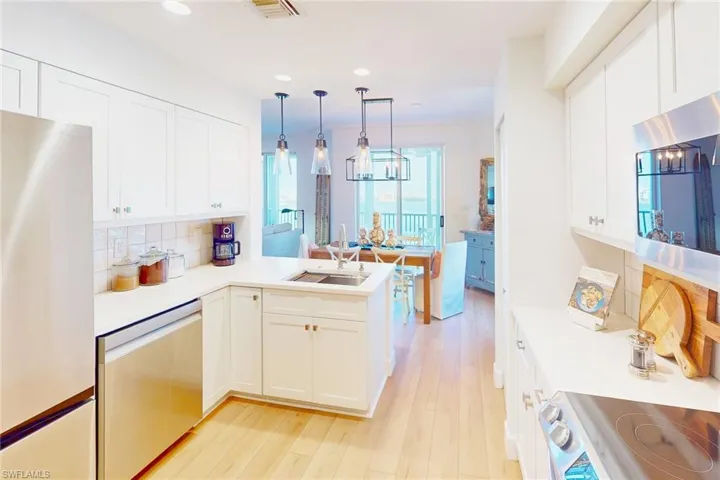 Kitchen featuring recessed lighting, light countertops, stainless steel appliances, and a sink