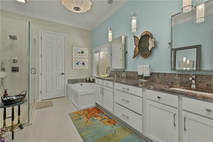 Bathroom with crown molding, shower with separate bathtub, vanity, and decorative backsplash