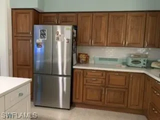 Kitchen featuring stainless refrigerator and quartz countertops
