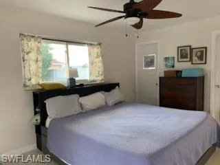 Bedroom with ceiling fan and light colored carpet