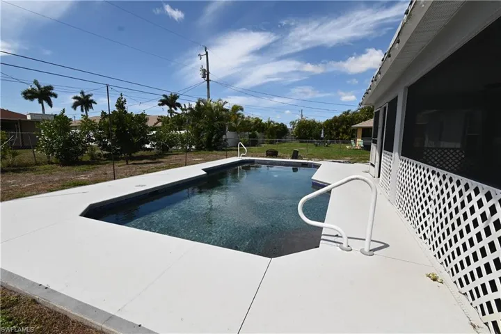 Swimming pool with a fenced backyard and a patio